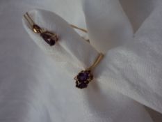 An Amethyst and Diamond ring set with a pair of oval amethysts flanked by two round brilliant cut