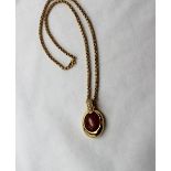 An 18ct yellow gold diamond and hardstone pendant on an 18ct yellow gold chain,