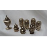 A pair of late Victorian silver pepperettes of domed swirling shape on three ball feet, London,