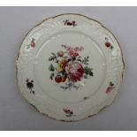 A Nantgarw porcelain plate painted to the centre with a spray of garden flowers,