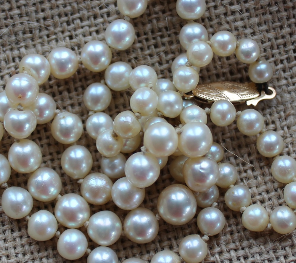 A string of graduated regular pearls, to a yellow metal clasp, varying from 8mm to 4mm,