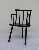 An 18th century comb back elbow chair, with a solid seat on three legs,