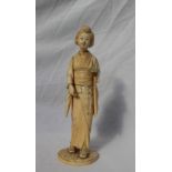 A 19th century Japanese ivory figure of a geisha, on a circular base with an inset red seal mark,