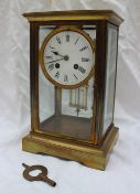 A brass four glass mantle clock, the circular enamel with Roman numerals,