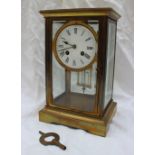 A brass four glass mantle clock, the circular enamel with Roman numerals,