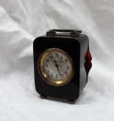 A Tortoise shell carriage clock, with a silver loop handle, on ball feet,