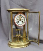 A late 19th / early 20th century oval brass four glass mantle clock the circular dial with Roman