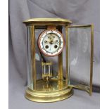 A late 19th / early 20th century oval brass four glass mantle clock the circular dial with Roman