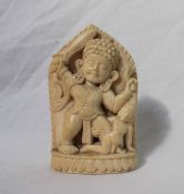 A 19th century carved ivory figure of an Indian God holding a sword in his right hand and the hair