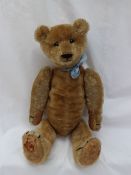 A mohair teddy bear with a movable head, arms and legs, with a hump back, and felt pads,