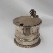 A late Victorian silver mustard pot, the circular lid with a pierced thumb piece,