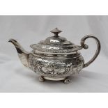 A George IV Scottish silver teapot of squat form embossed with flower heads and leaves on ball feet,