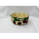 A 19th century pottery bowl of scalloped circular shape painted with plums and leaves,