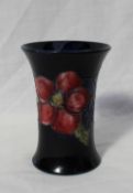 A Moorcroft pottery vase of flared form decorated with Clematis to a Royal blue ground,