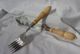 A Victorian silver and ivory fish servers, the blade and fork engraved with flower heads and leaves,