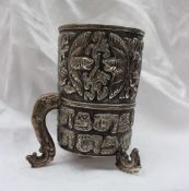 A white metal mug, decorated with birds, flowerheads and leaves, possibly Thai,