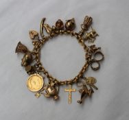 A 9ct yellow gold bracelet set with numerous charms including a half sovereign, pig, hand bell,