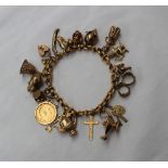 A 9ct yellow gold bracelet set with numerous charms including a half sovereign, pig, hand bell,