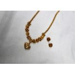 A yellow metal necklace with a central heart, diamond and star shaped links, with matching earrings,