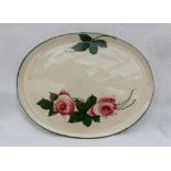 A Llanelly pottery oval dish decorated with roses and leaves to a green line border,