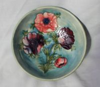 A Moorcroft pottery footed bowl, decorated with poppies to a green ground, impressed marks,