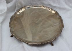 A George V silver salver, with a shaped gadrooned edge on four hoof feet, Chester, 1912,