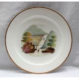 A 19th century porcelain plate painted with a waterfall scene to a gilt border,