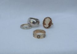 A 9ct gold band set with faux screw heads, two diamonds and another stone,