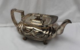 A late George III silver teapot of squat oval form with wave decoration, on lions paw feet, London,