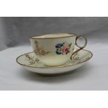 A Swansea teacup and saucer, painted with roses and blue flowers with geometric gilt decoration,