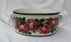 A Wemyss pottery footbath, painted with roses and leaves, with a broad green rim,
