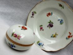 A Meissen porcelain dish, painted with floral specimens to a shaped gilt edge,