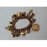 A 9ct yellow gold bracelet with oval links set with numerous charms including a St Christopher,