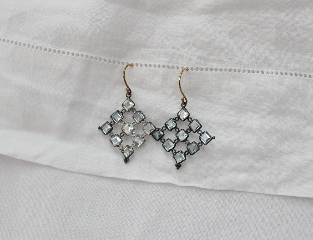 A pair of topaz earrings set with nine square stones in a square formation