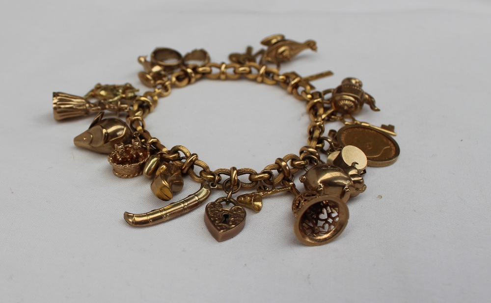 A 9ct yellow gold bracelet set with numerous charms including a half sovereign, pig, hand bell, - Image 2 of 3