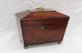 A Victorian mahogany sarcophagus tea caddy, the hinged lid enclosing two lidded compartments,