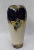 A Moorcroft pottery vase, decorated in the pansy pattern, to a cream ground,