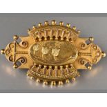 A 15CT YELLOW GOLD GOLD MOMENTMOIRE BROOCH, the centre decorated with flowers surrounded by scrolls,