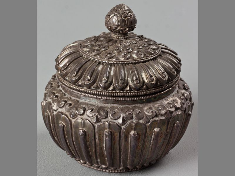 A 19TH CENTURY TIBETAN SILVER COVERED SUGAR BASIN, finely cast wiith lappets aournd the body, the