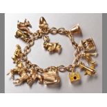 A 9CT YELLOW GOLD CHARM BRACELET, comprising of thirteen various charms, belcher links with clasp,