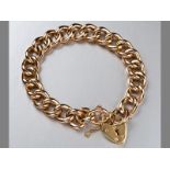 A 9CT YELLOW GOLD BRACELET, hallow curb-links with heart lock and safety chain, 19cm long, 16.4g.