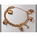 A 9CT YELLOW GOLD CHARM BRACELET, comprising of seven various charms, curb-links with heart lock and