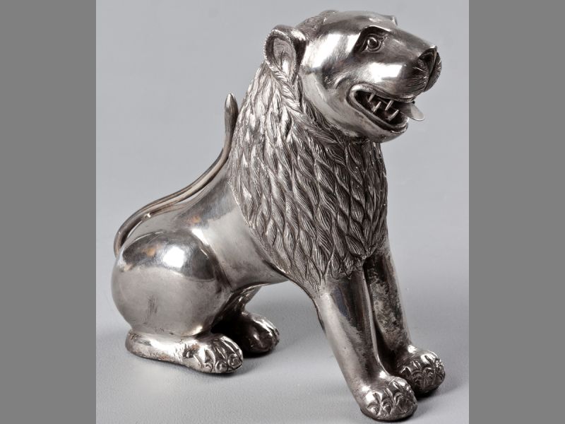 AN AMUSING 19TH CENTURY SILVER MODEL OF A LION, probably Indian, the mane finely worked, filled,