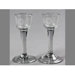 A PAIR OF ENGLISH WINE GLASSES, CIRCA 1750, engraved with ogee bowl with a single rose above a plain