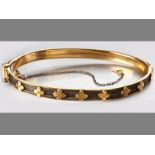 AN 18CT YELLOW GOLD AND ELEPHANT HAIR BANGLE, hinged bangle decorated with gold floral form with a