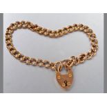 A 9CT YELLOW GOLD BRACELET, with curb links, a heart shaped lock and safety chain, 19cm long, 15g.