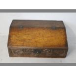 A CHARLES II OAK WRITING BOX, the fall with chip carving above an ornately carved frieze bearing the