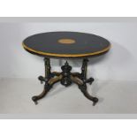 AN EDWARDIAN WALNUT EBONIZED OVAL TABLE, the top inlaid with a central lozenge above a beaded frieze