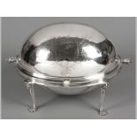 A SILVERPLATE REVOLVING BREAKFAST DISH, the domed cover engraved with leaves and flowers, the