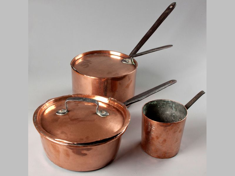 A GROUP OF THREE COPPER SAUCE PANS, with lids and iron handles, of various constructions, 62cm